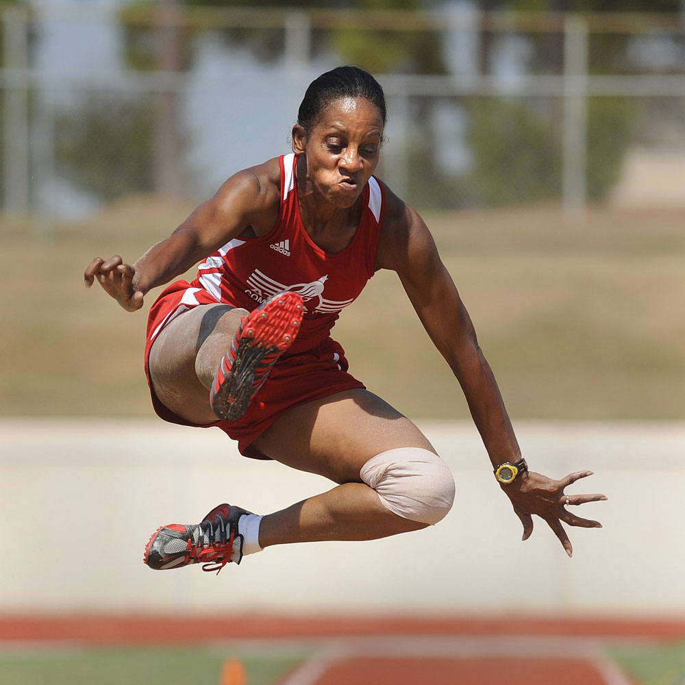A woman jumping in a track and field event.